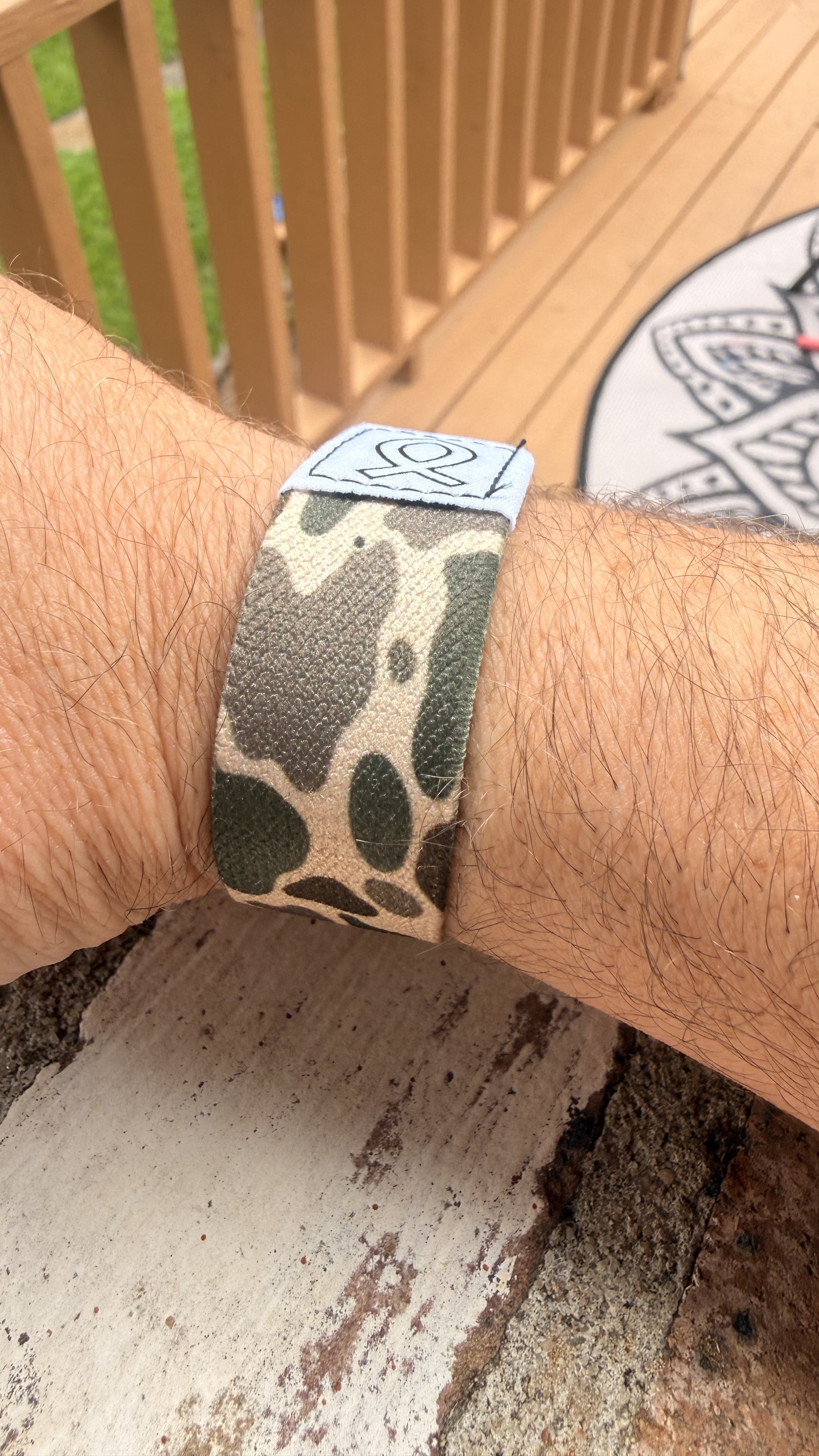 Camo Bible Band scripture wristband tapped with a phone for daily devotion